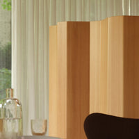 Elegant light wood screen with smooth, vertical lines, complemented by soft, neutral tones and sheer drapery in the background.