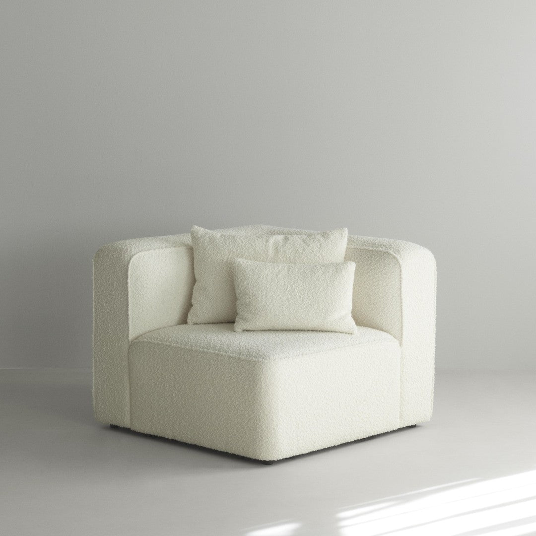 White textured corner sofa with two matching cushions in a minimalist setting. Elegant and modern design.