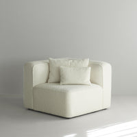 White textured corner sofa with two matching cushions in a minimalist setting. Elegant and modern design.