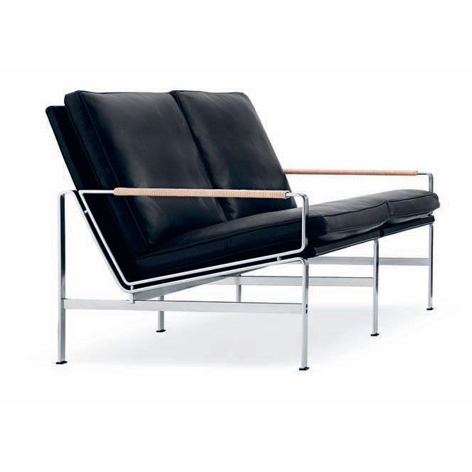 Black leather sofa with chrome frame and wooden armrests, featuring a sleek, modern design.