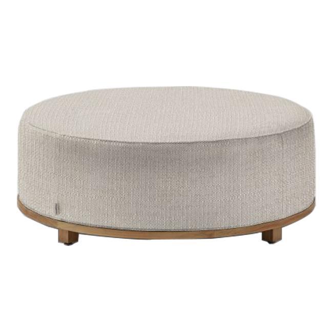 Round beige ottoman with subtle textured patterns and a natural wood base. Perfect for modern decor.