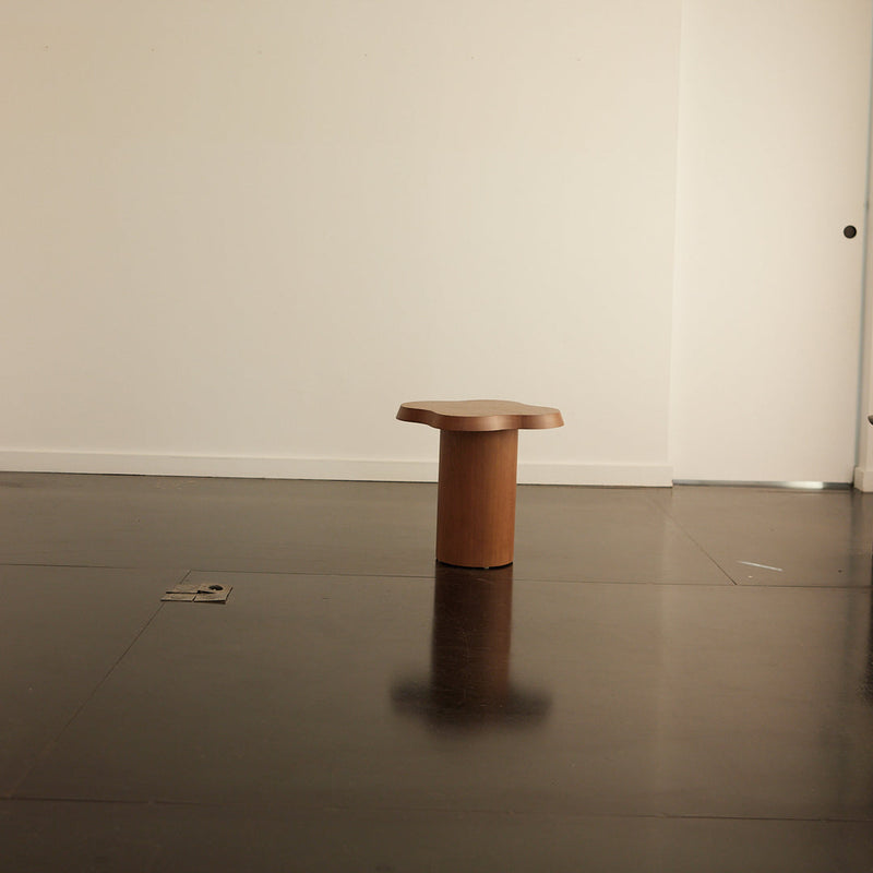 Light wood stool with a smooth, natural finish, set against a minimalist light-colored background. Ideal for modern decor.