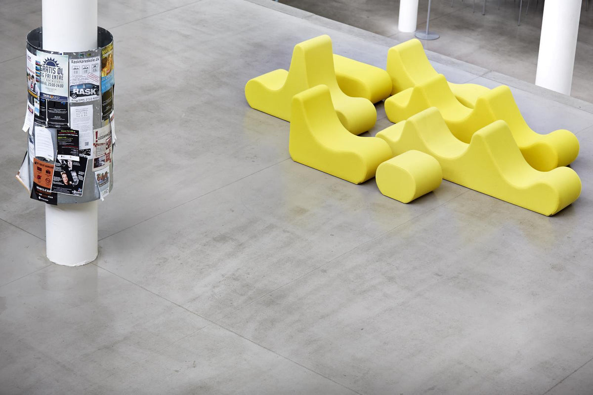 Bright yellow contemporary seating pattern on a smooth gray floor, adding a lively touch to modern spaces.