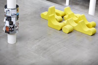 Bright yellow contemporary seating pattern on a smooth gray floor, adding a lively touch to modern spaces.