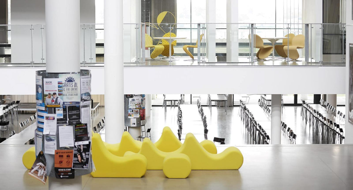Bright yellow seating with smooth, organic shapes in a minimalist, modern space. Light-filled ambiance enhances colors.