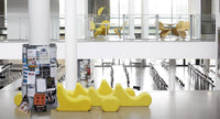 Modern yellow furniture with a smooth, flowing design against a minimalist white and gray background.