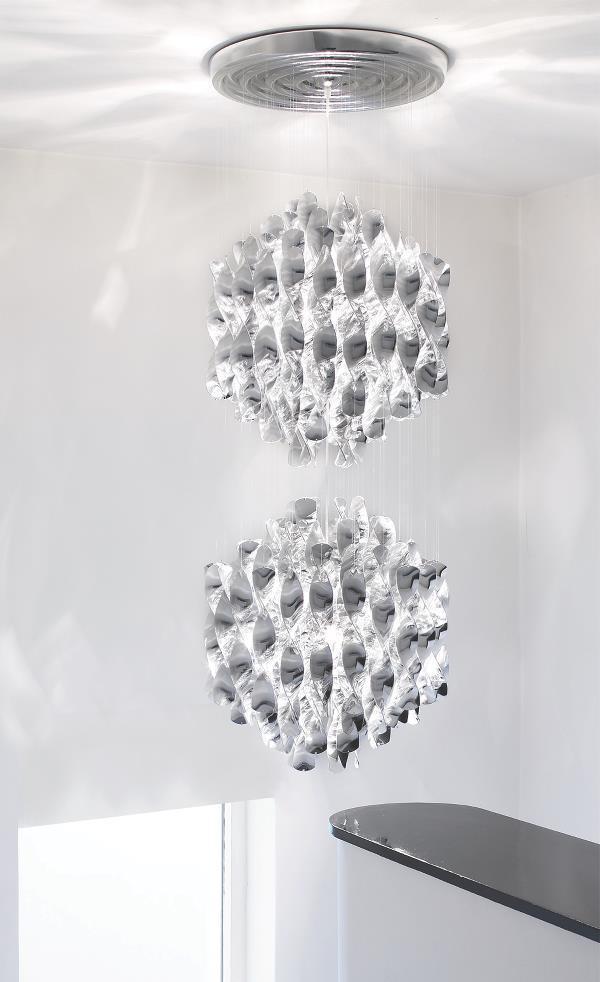 Elegant dual crystal pendant lights with intricate geometric patterns in clear glass against a white backdrop.