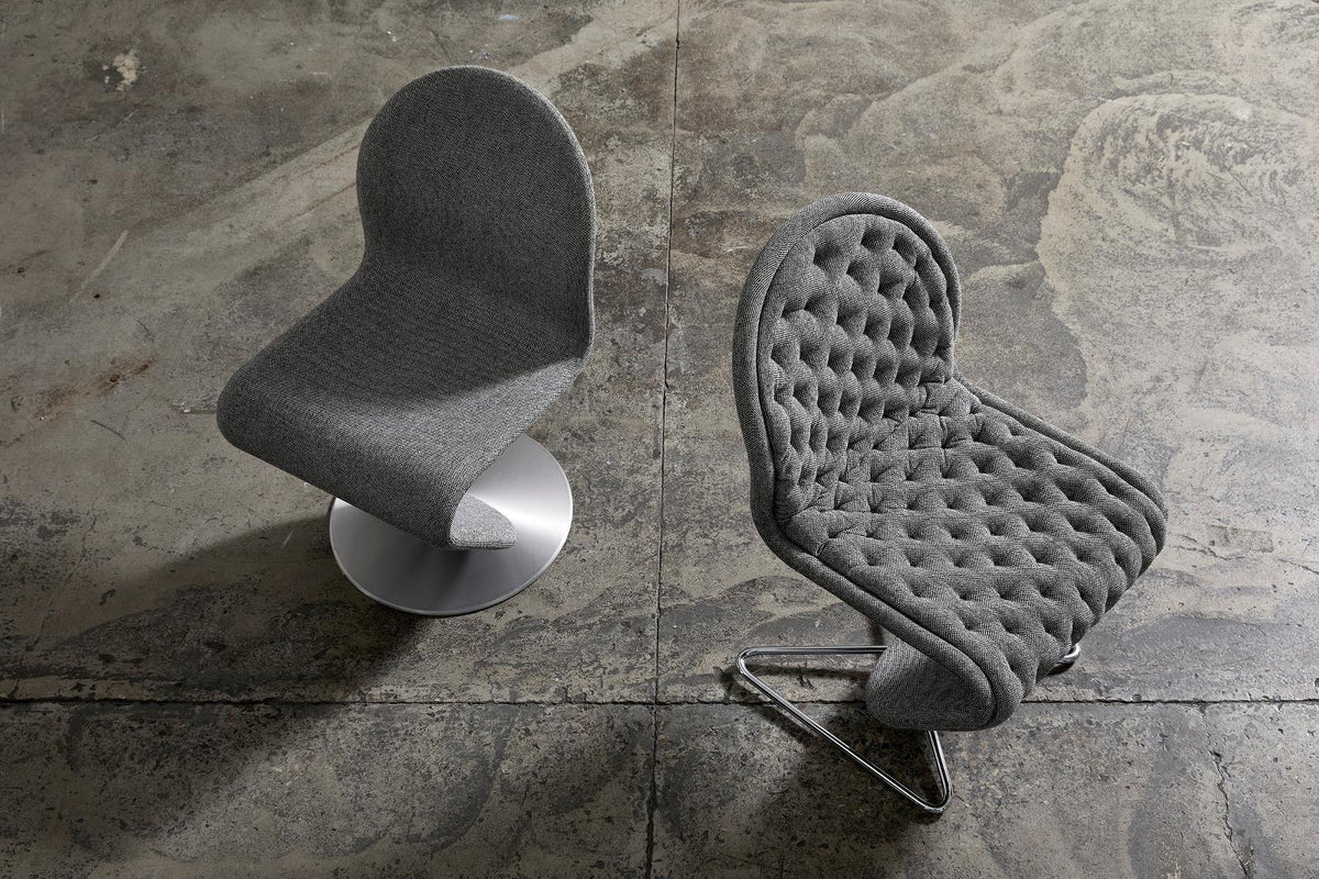 Gray textured chairs with tufted and smooth patterns, set against a concrete background.