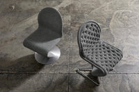 Gray textured chairs with tufted and smooth patterns, set against a concrete background.