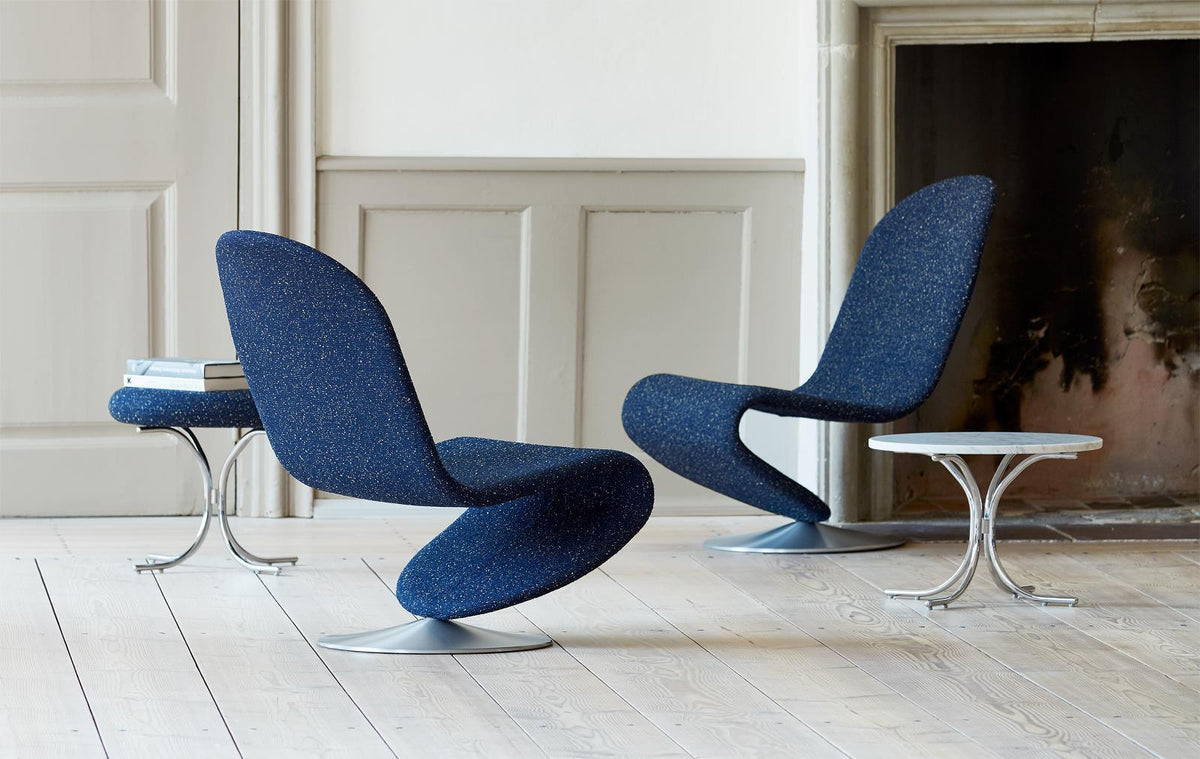 Navy blue chairs with a speckled pattern and silver bases, set on a light wooden floor.