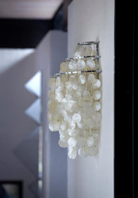 White circular decor hanging on a silver rack, creating a modern and elegant pattern.