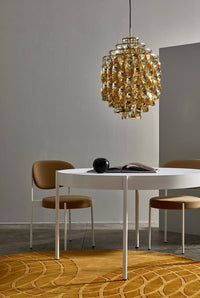 "Modern dining setup featuring gold accents, white table, and a warm yellow patterned rug."
