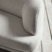 Light gray textured upholstery with a soft, modern curve, set against a natural wood background.