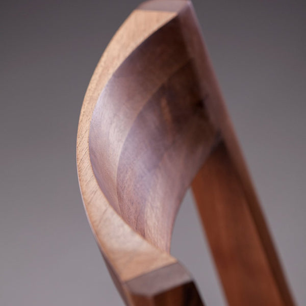 Curved wooden design showcasing rich brown tones with smooth, polished texture. Perfect for modern decor.