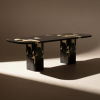Black and gold patterned table with a sleek design, featuring striking geometric shapes and a modern aesthetic.