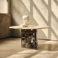 Elegant round table with a light wood top and a patterned black and silver geometric base. Ideal for modern decor.
