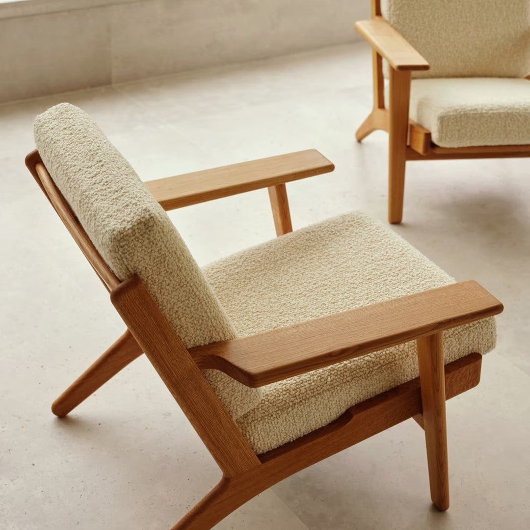 Cream-colored textured upholstery with light wood frame, featuring clean lines and minimalist design.