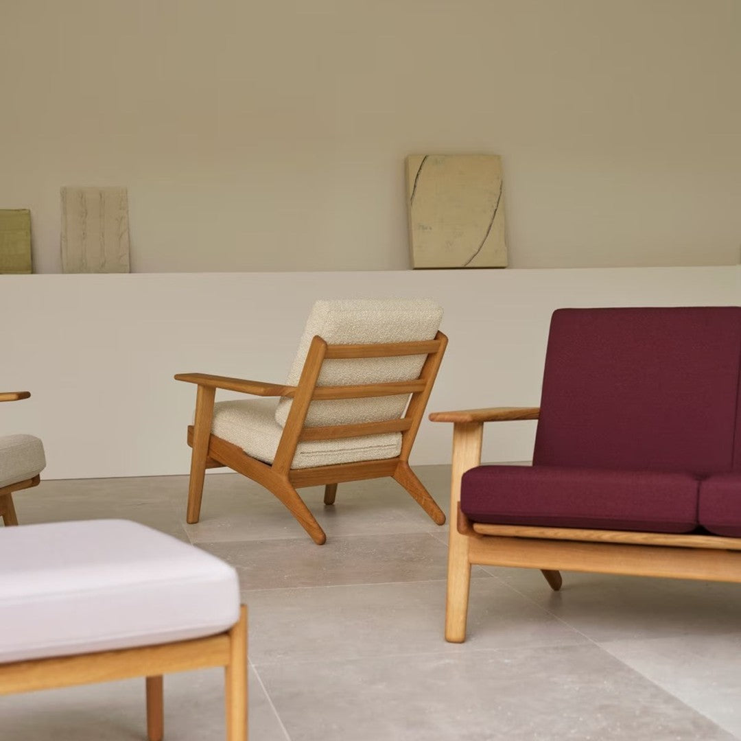 Stylish wooden chairs in cream and burgundy upholstery, featuring a minimalist design in a neutral-toned setting.