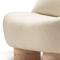 Beige textured upholstery on a curvy chair with light-toned cork legs. Elegant and modern design.