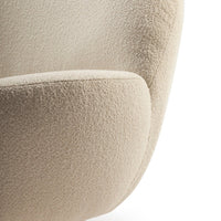 Beige textured fabric of a modern chair with a soft, fuzzy pattern, highlighting its cozy appeal.