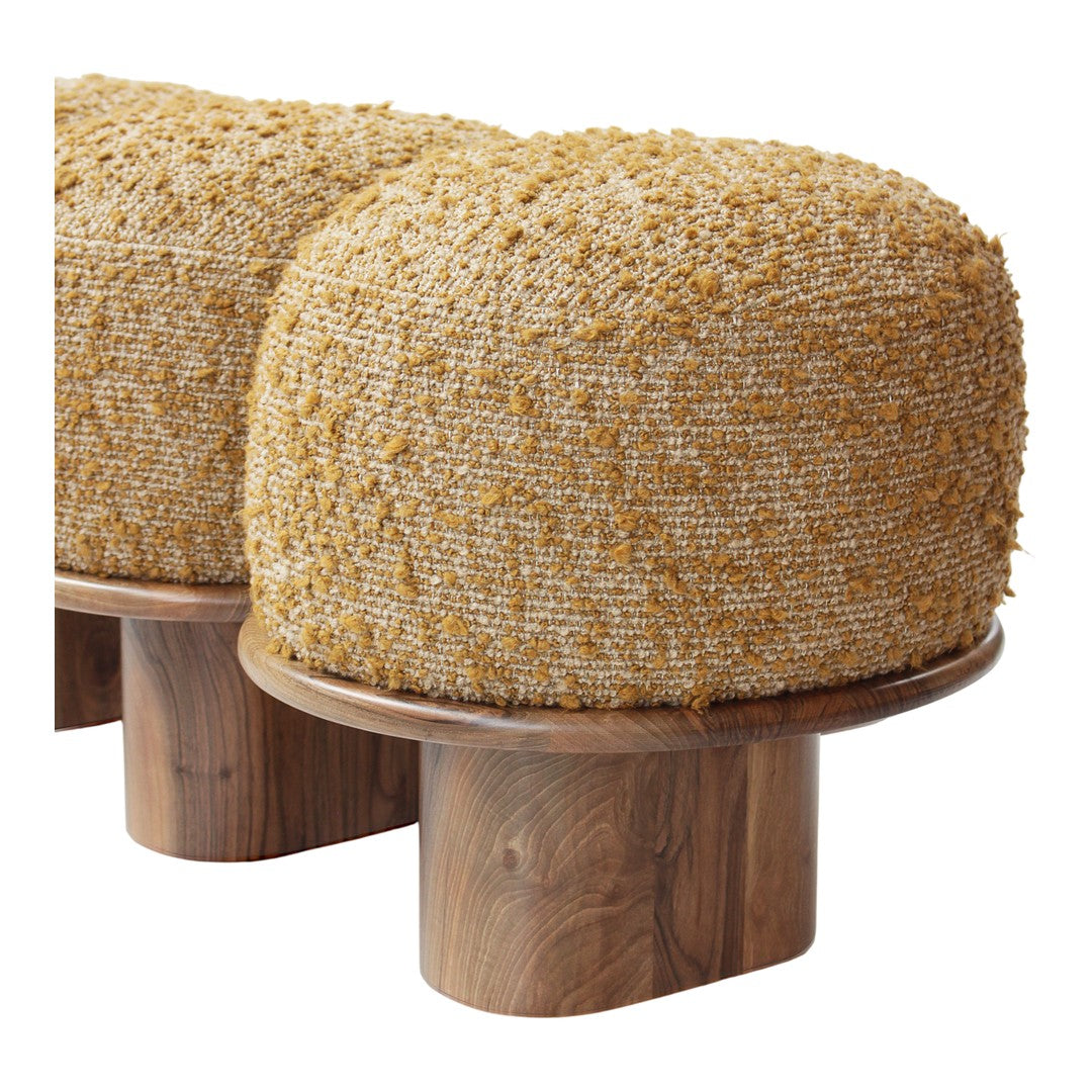 Textured round pouf in warm golden yellow with a soft, fuzzy surface, resting on a natural wood base.