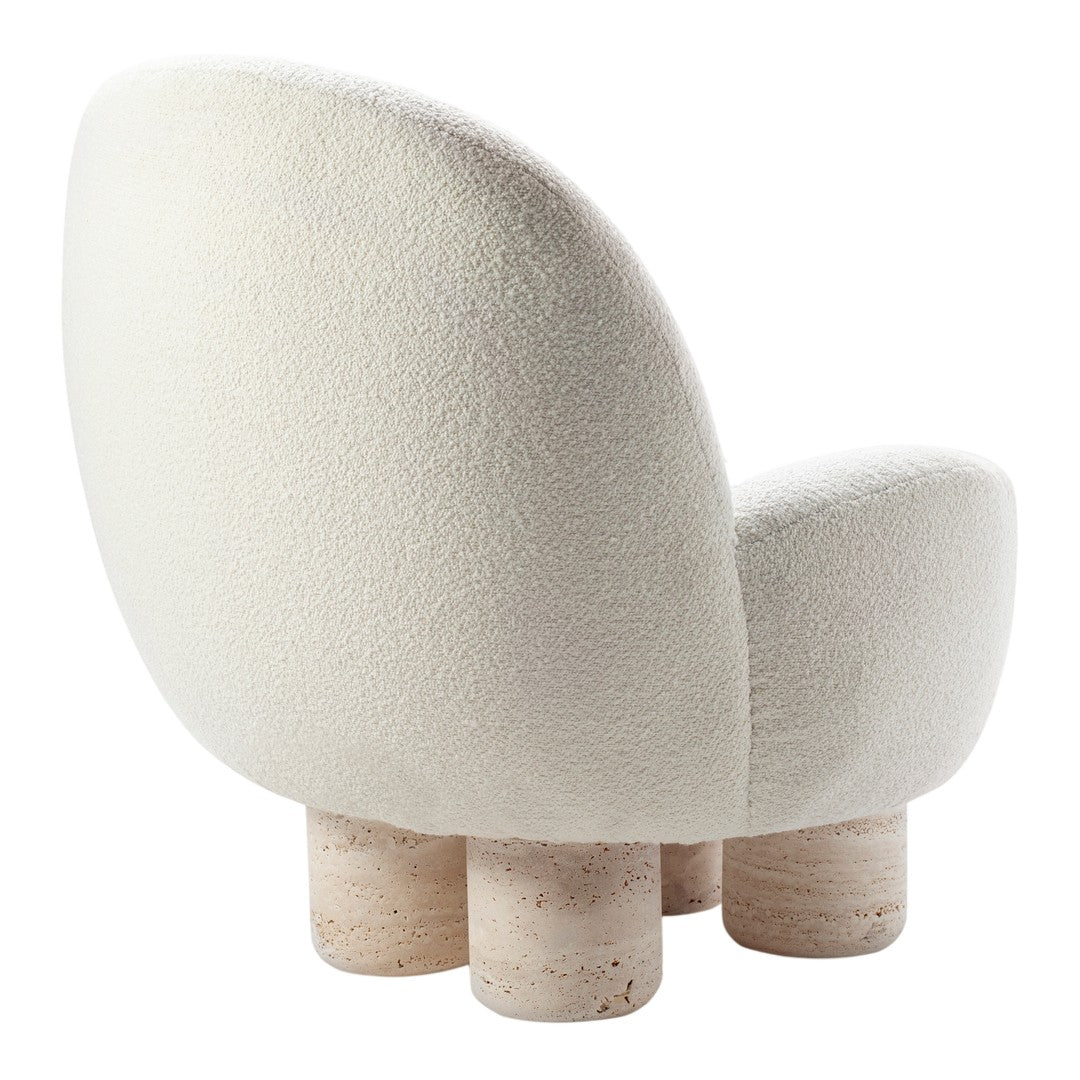 Cream-colored cozy chair with soft, textured upholstery and circular stone-like legs. 