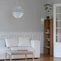 Modern white pendant lamp with layered design, set against neutral gray walls and light wood accents. Elegant, minimalist style.