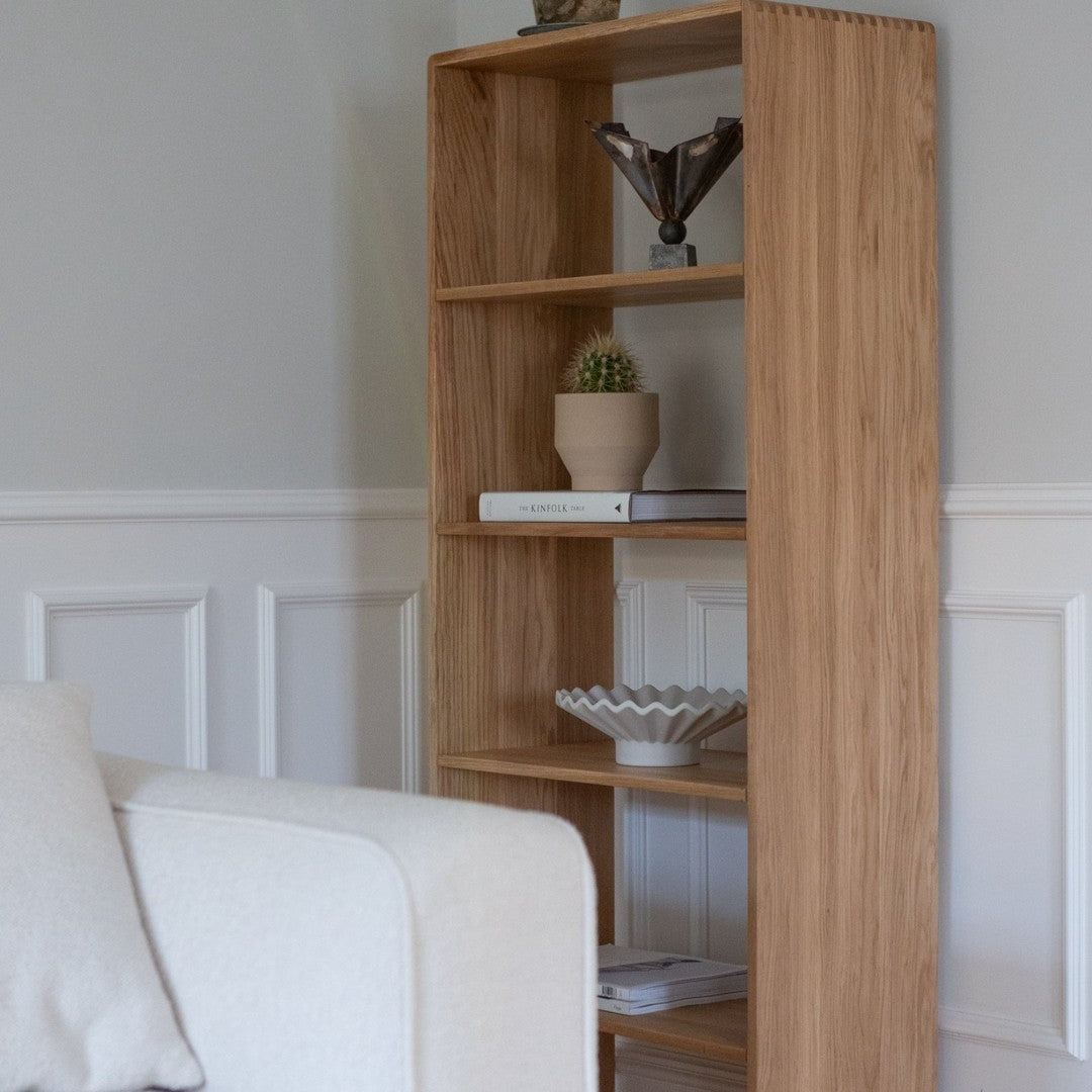 Light wood bookshelf with natural grain, featuring clean lines and minimalistic design against a neutral background.