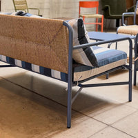 Stylish outdoor sofa featuring natural beige and navy striped cushions with a sleek metal frame. Perfect for patio decor.