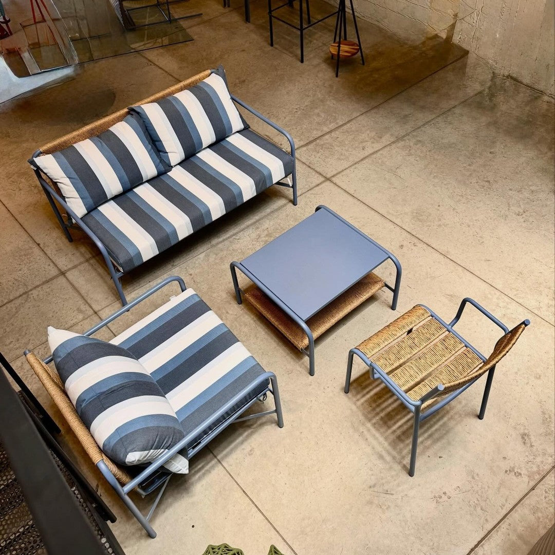 Sleek outdoor furniture set featuring navy and white striped cushions with natural wood accents and a blue tabletop.