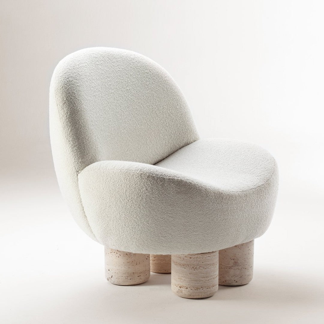 Soft white boucle upholstery with rounded silhouette and light stone-colored legs, creating a modern, minimalist look.