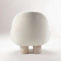White textured upholstery with rounded shape, featuring natural-looking cork legs for a modern, minimalist aesthetic.