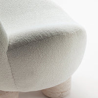 Textured light gray upholstery with a soft, fuzzy finish on a curved furniture piece, featuring beige circular legs.
