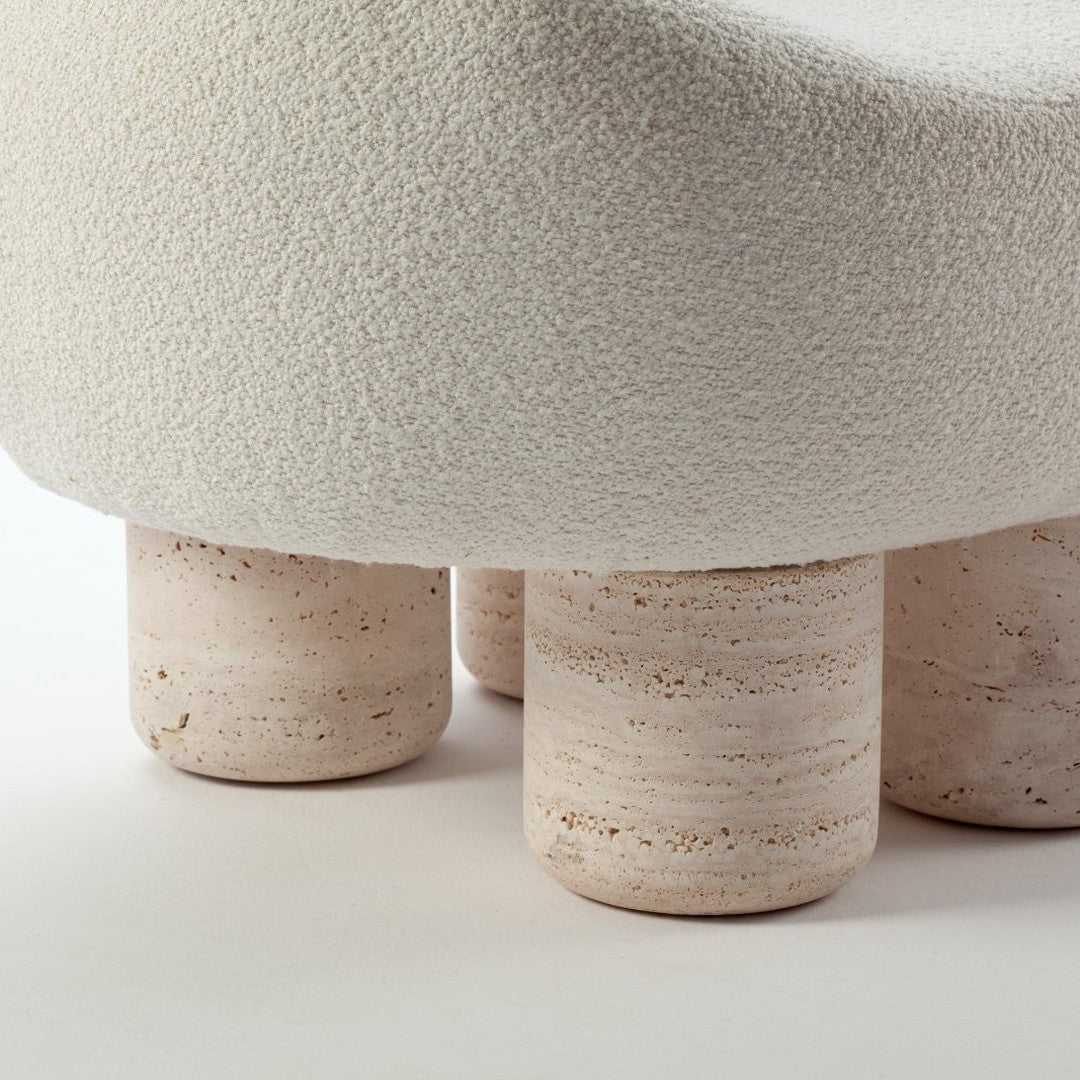 Textured cream upholstery with beige, stone-like legs; soft, subtle color palette enhances modern design.