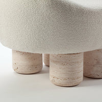 Textured cream upholstery with beige, stone-like legs; soft, subtle color palette enhances modern design.