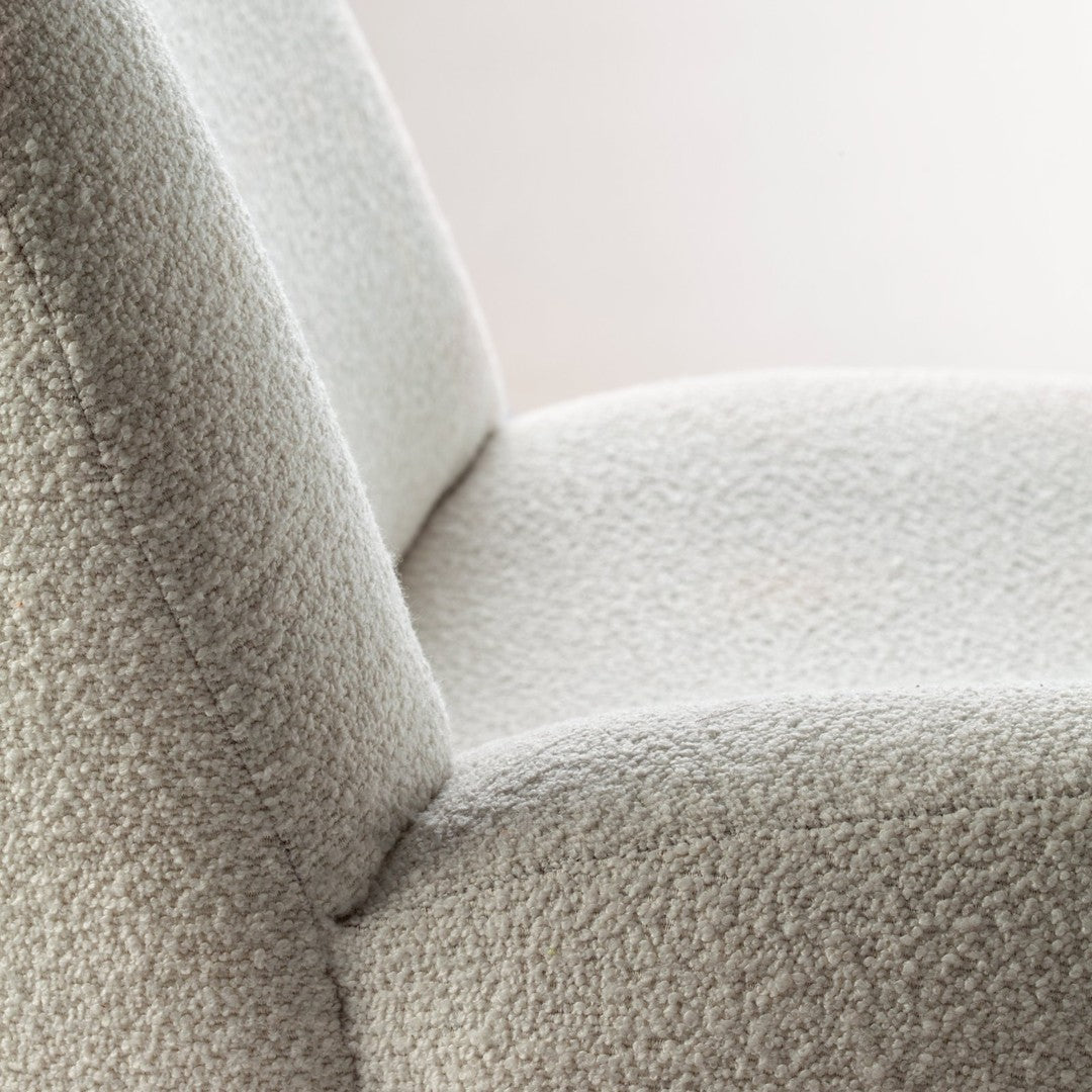 Textured cream fabric close-up, featuring a soft, cozy pattern that enhances the modern chair's aesthetic appeal.