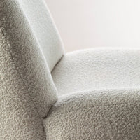 Textured cream fabric close-up, featuring a soft, cozy pattern that enhances the modern chair's aesthetic appeal.