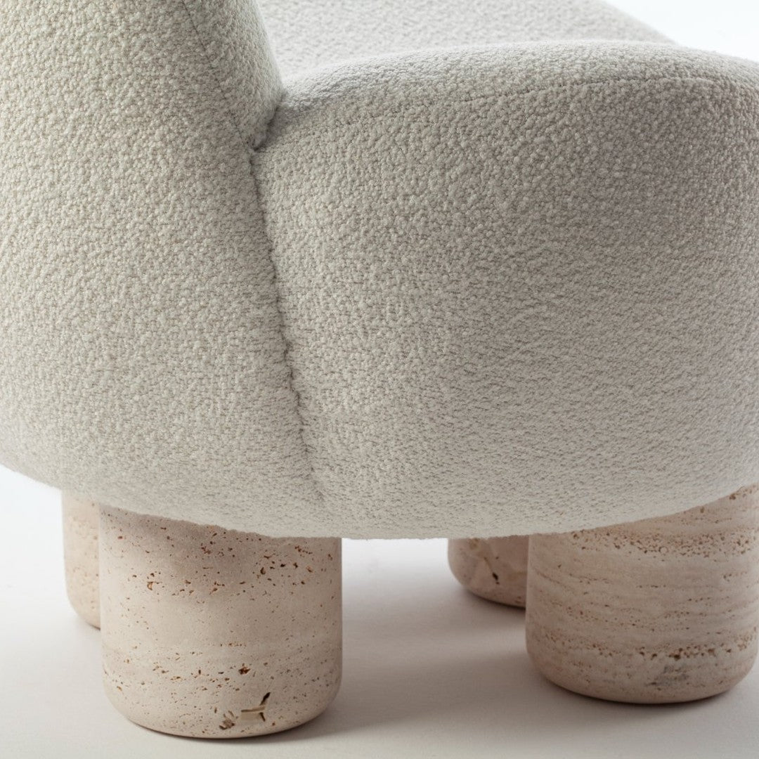 Textured white upholstery with rounded shape and light beige stone legs. Elegant and modern design detail.