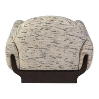 Textured beige fabric with subtle gray and black speckles, featuring a smooth dark wood base. Modern accent chair design.