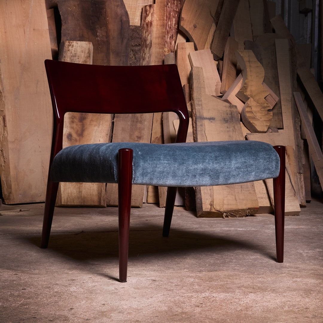 Mid-century chair featuring a rich mahogany frame and soft blue upholstery. Simple, elegant design. Ideal for modern decor.