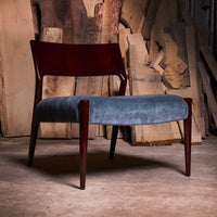 Mid-century chair featuring a rich mahogany frame and soft blue upholstery. Simple, elegant design. Ideal for modern decor.