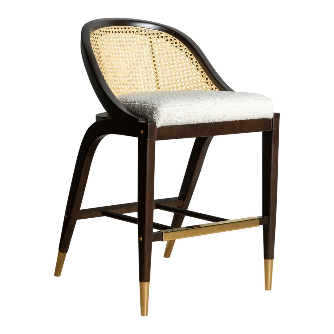 Brown wooden bar stool with natural cane seating and a white upholstered cushion, featuring brass-finished legs.
