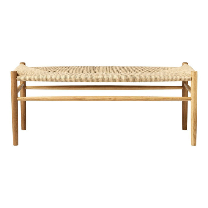 Natural wood bench with a woven beige seating surface, featuring a minimalist design and earthy tones. Perfect for any space.