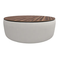 Round coffee table with a smooth white cushion base and a rich dark wood patterned top. Elegant and modern design.