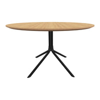 Round wooden dining table with a natural oak finish and a sleek black metal base. Modern and minimalist design.