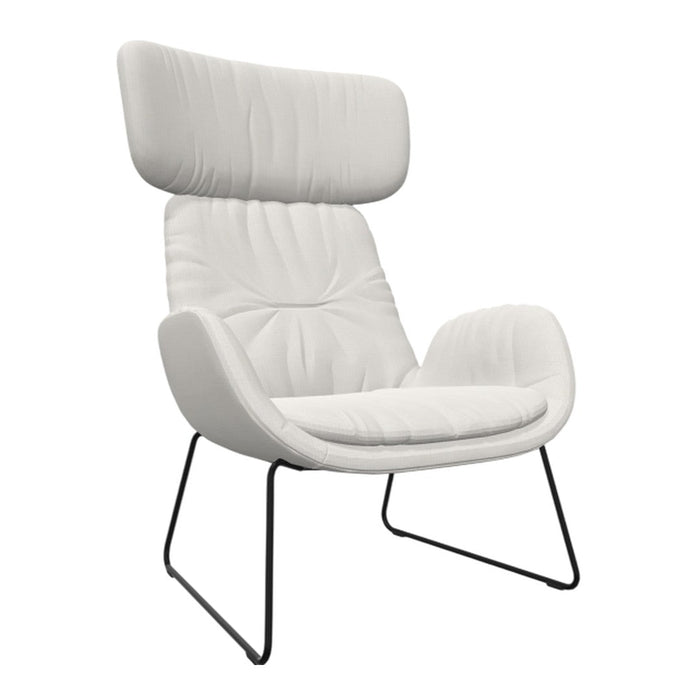White upholstered armchair with a textured, quilted pattern, complemented by sleek black metal legs.