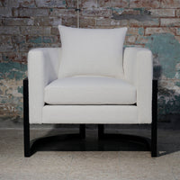 White upholstered chair with a solid black frame and a matching accent pillow, perfect for modern decor.