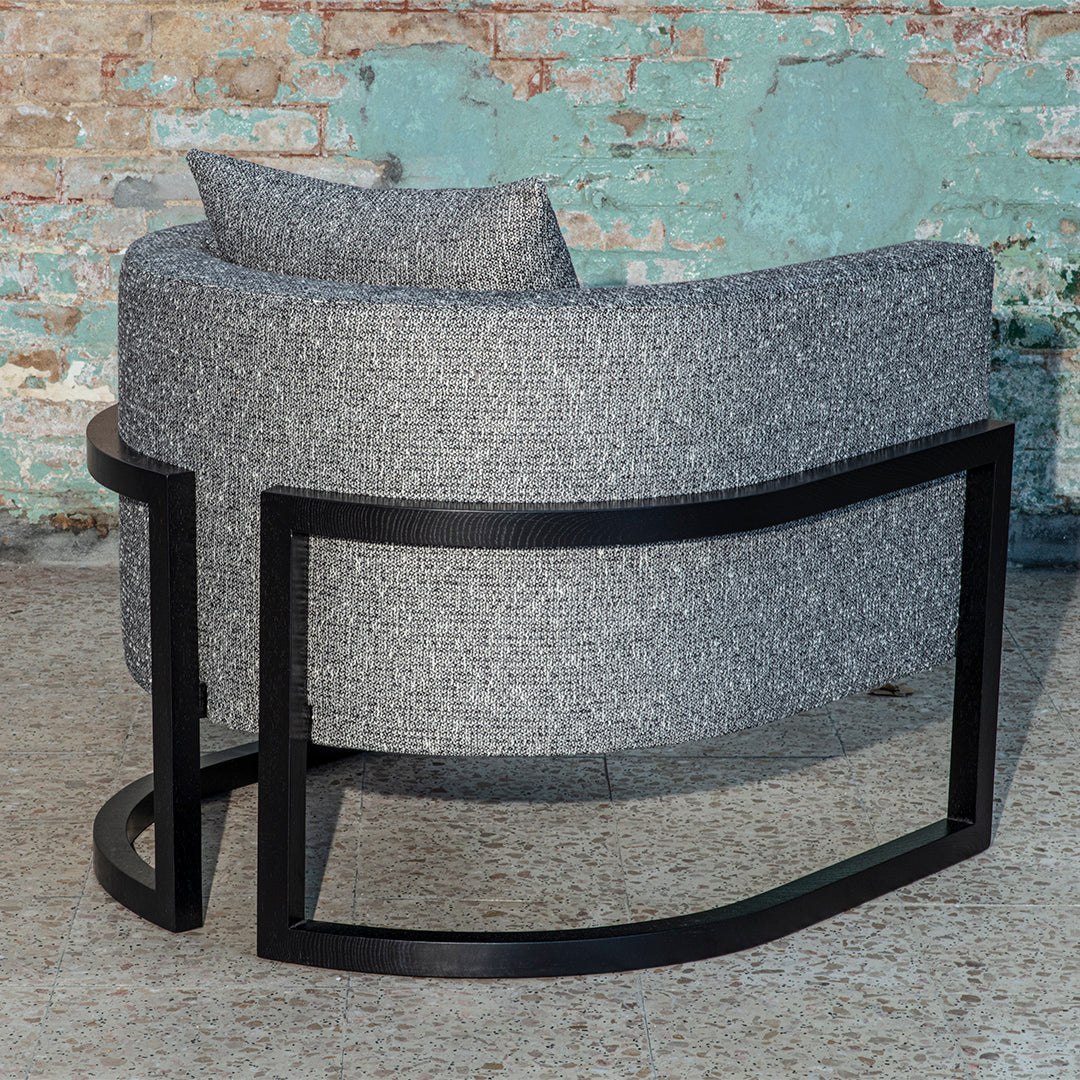 Gray textured fabric chair with a sleek black metal frame, featuring a minimalistic curved design.