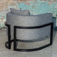 Gray textured fabric chair with a sleek black metal frame, featuring a minimalistic curved design.