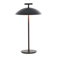 Black dome lamp with a sleek, minimalist design and a warm copper accent on the stem.